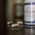 Bottle of L theanine supplement with capsules next to it